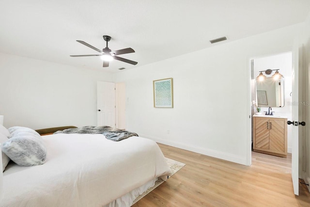 bedroom featuring connected bathroom, light hardwood / wood-style flooring, sink, and ceiling fan