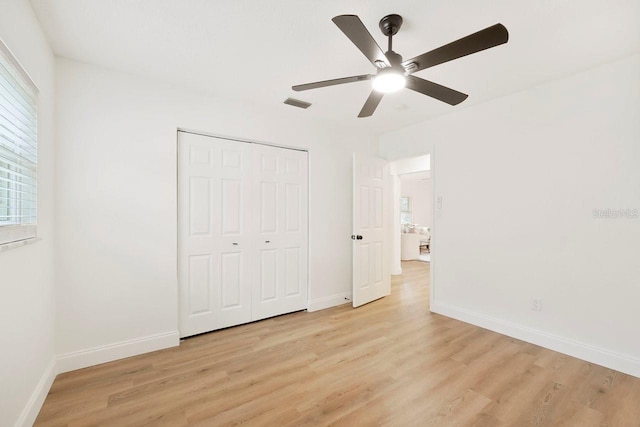 unfurnished bedroom with ceiling fan, a closet, and light hardwood / wood-style flooring