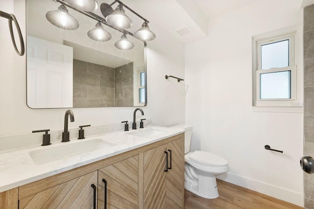 bathroom with hardwood / wood-style flooring, vanity, and toilet