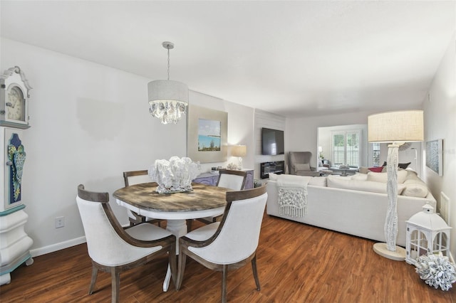 dining area featuring a notable chandelier, dark wood-style flooring, and baseboards