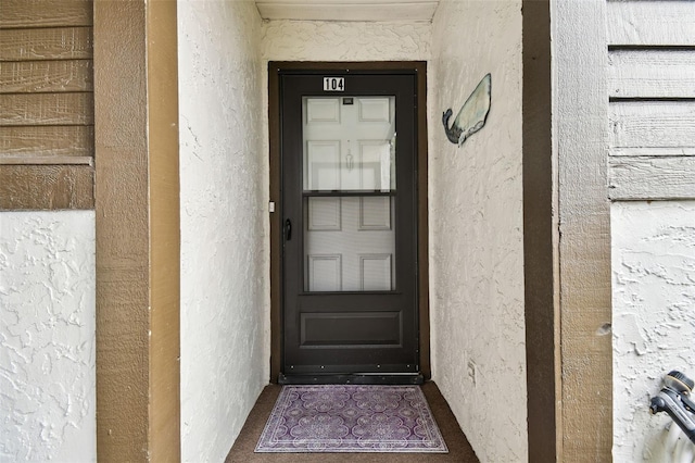 view of exterior entry with stucco siding