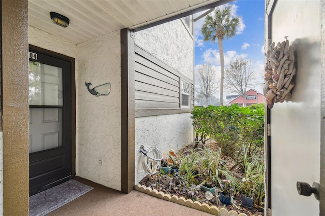 doorway to property featuring stucco siding