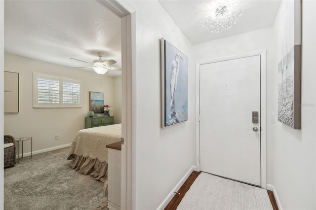 interior space featuring a textured ceiling, ceiling fan, and baseboards