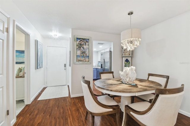 dining room with dark wood finished floors, baseboards, and a chandelier