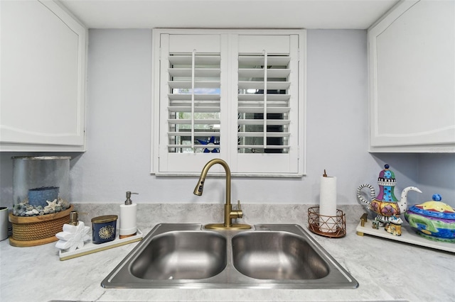 details with white cabinetry, light countertops, and a sink