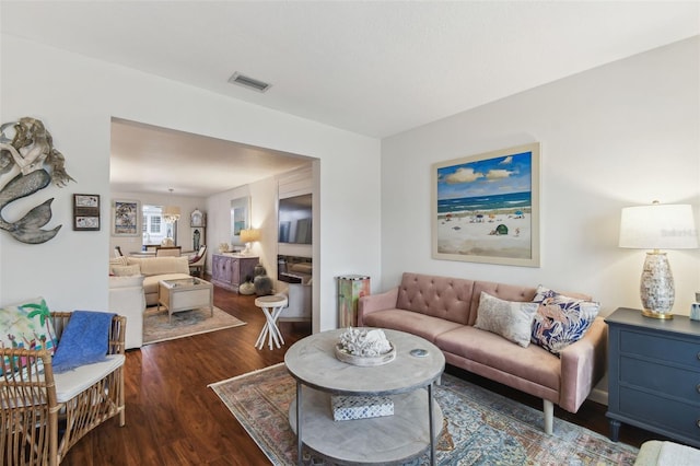 living area featuring visible vents and wood finished floors