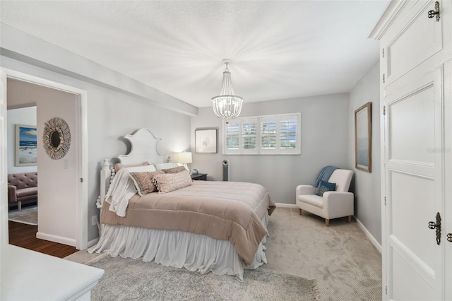 bedroom featuring an inviting chandelier and baseboards