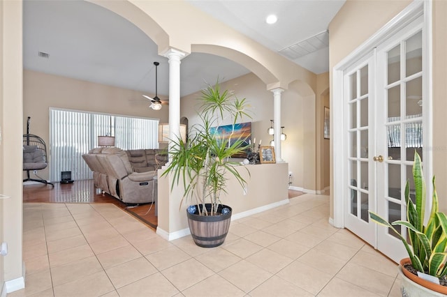 interior space featuring ornate columns, ceiling fan, and light tile patterned floors