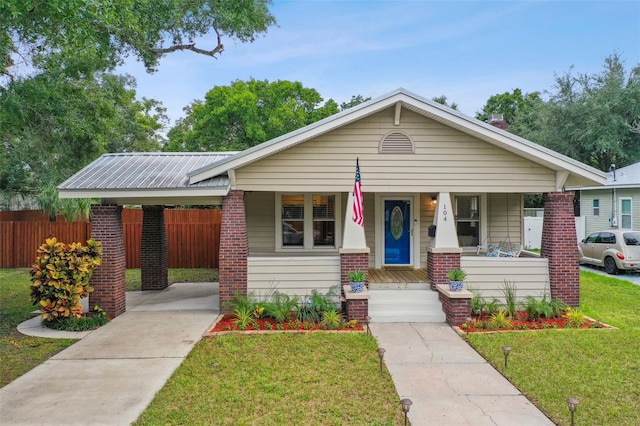 view of front facade with a porch, a carport, and a front lawn