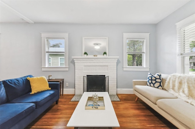 living room with a fireplace, a wealth of natural light, and dark hardwood / wood-style floors