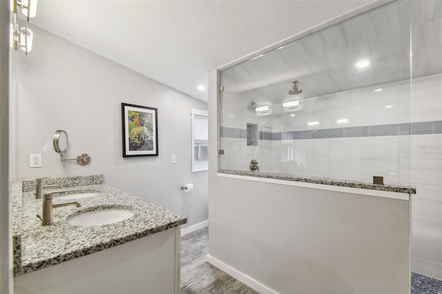 bathroom with vanity, tiled shower, and hardwood / wood-style floors