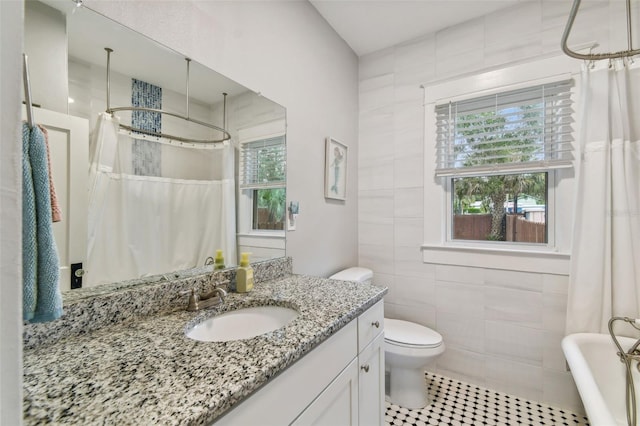 bathroom featuring tile patterned floors, toilet, a shower with curtain, tile walls, and vanity