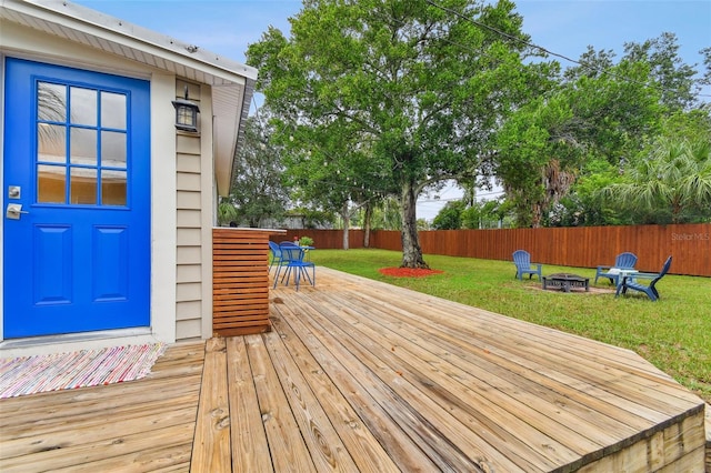 wooden deck featuring an outdoor fire pit and a yard