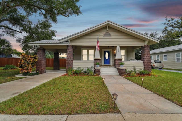 view of front of house with covered porch and a lawn