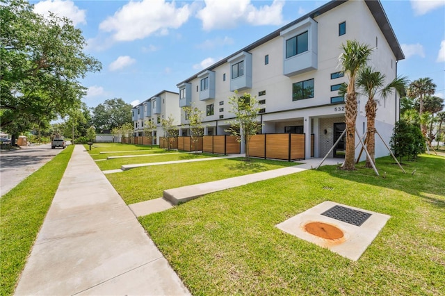 view of home's community with a residential view, fence, and a lawn