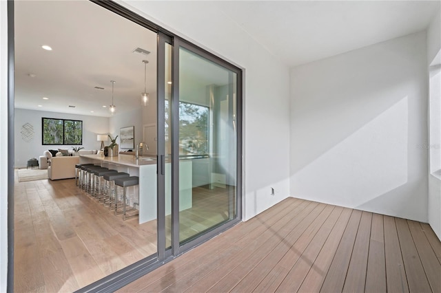 interior space featuring light wood finished floors, a sink, visible vents, and recessed lighting