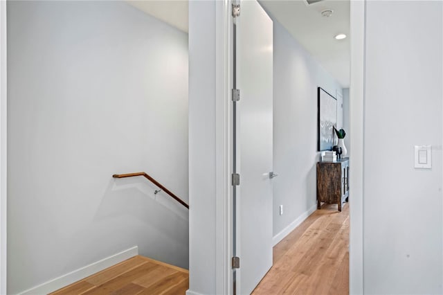 hall with recessed lighting, light wood-type flooring, an upstairs landing, and baseboards