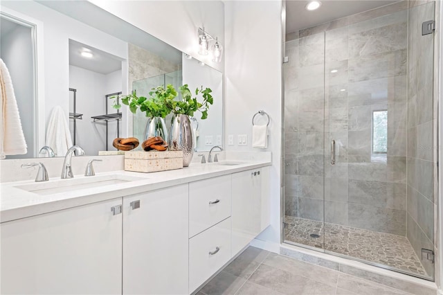 bathroom with double vanity, tile patterned floors, a sink, and a shower stall