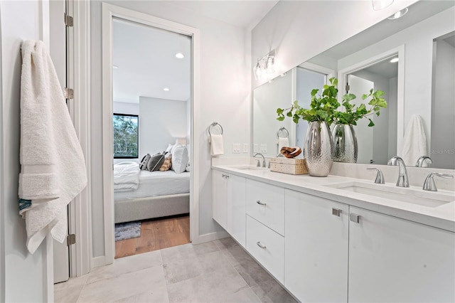 full bath featuring tile patterned flooring, a sink, ensuite bath, and double vanity