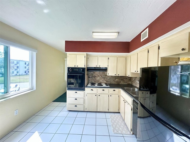 kitchen with tasteful backsplash, light tile patterned floors, a textured ceiling, and black appliances