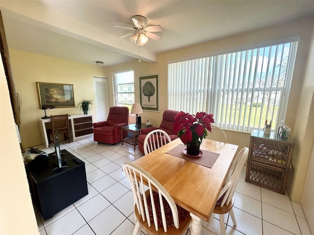 tiled dining area featuring ceiling fan and beamed ceiling