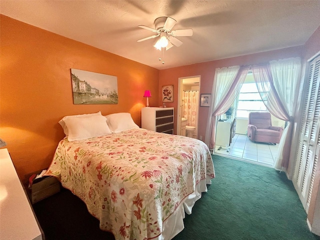 bedroom featuring ensuite bathroom, ceiling fan, and dark colored carpet