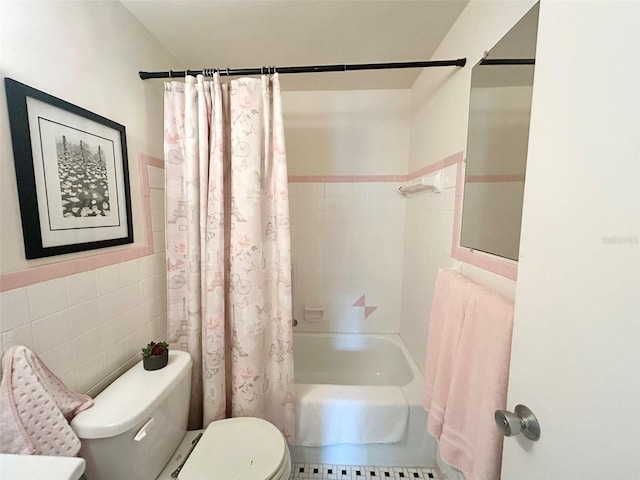 bathroom with toilet, tile walls, and shower / bath combo