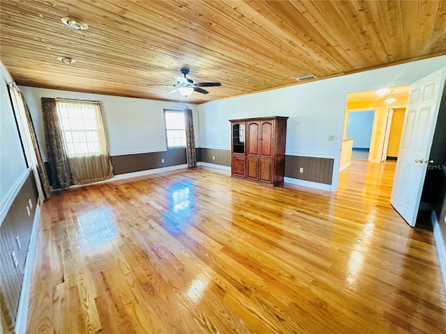 unfurnished living room featuring light hardwood / wood-style flooring, wooden ceiling, and ceiling fan
