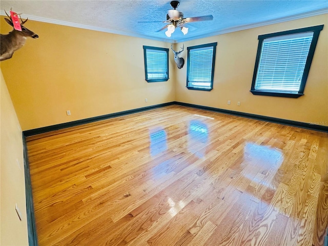 spare room featuring crown molding, ceiling fan, a textured ceiling, and light hardwood / wood-style flooring