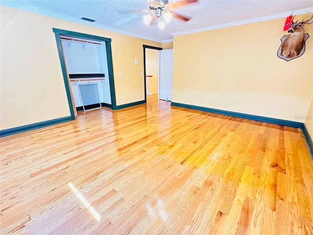 spare room with ceiling fan, crown molding, a textured ceiling, and light wood-type flooring