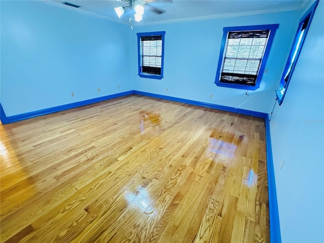 empty room with ornamental molding, ceiling fan, and light wood-type flooring