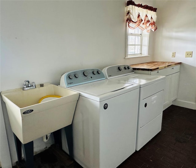 laundry area featuring dark wood-type flooring, cabinets, washer and clothes dryer, and sink