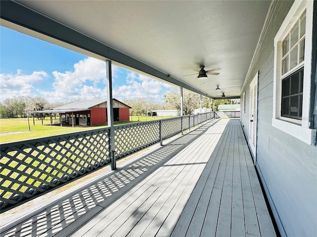wooden deck with ceiling fan and a yard