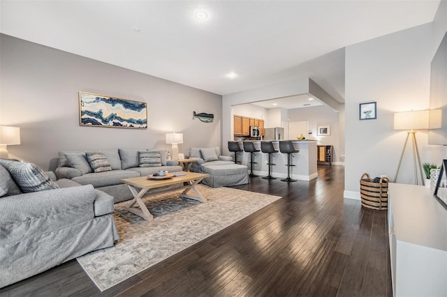 living room featuring dark wood-style floors, recessed lighting, and baseboards