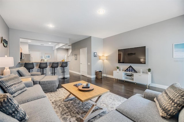 living area featuring baseboards, dark wood-style flooring, and recessed lighting