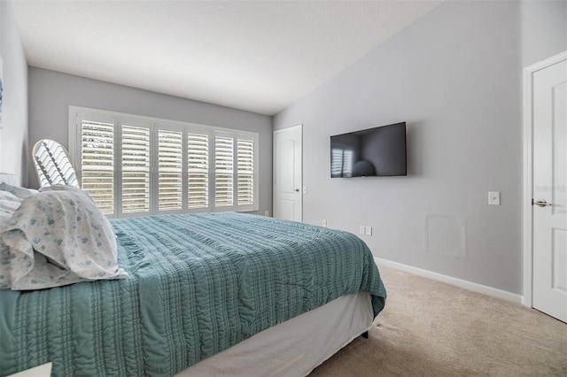 carpeted bedroom featuring baseboards and vaulted ceiling