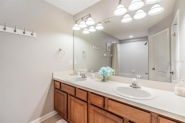 full bath featuring baseboards, double vanity, a sink, and shower / bathtub combination with curtain