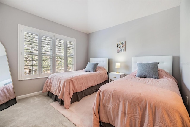 bedroom with baseboards and light colored carpet