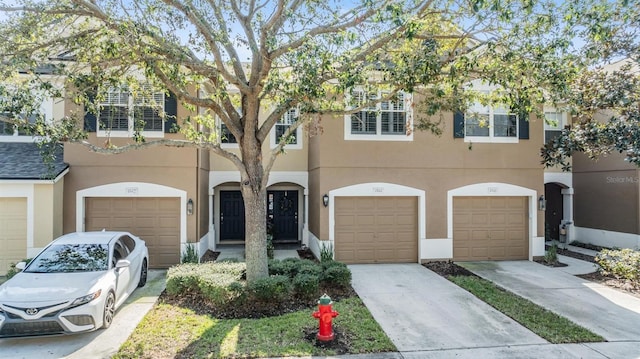 townhome / multi-family property featuring driveway and stucco siding