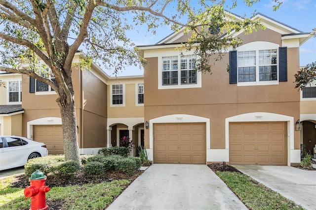 multi unit property with driveway, an attached garage, and stucco siding