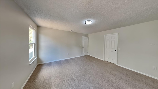 carpeted spare room with a textured ceiling