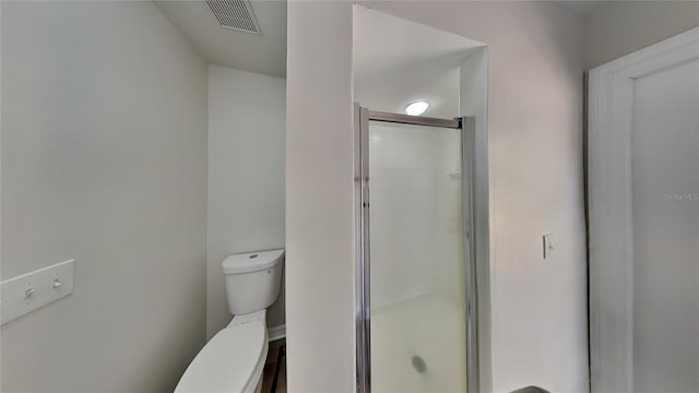 bathroom with toilet and a shower with door