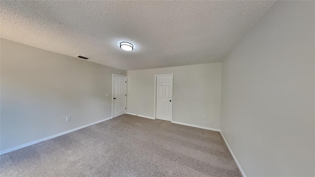 empty room with a textured ceiling and carpet