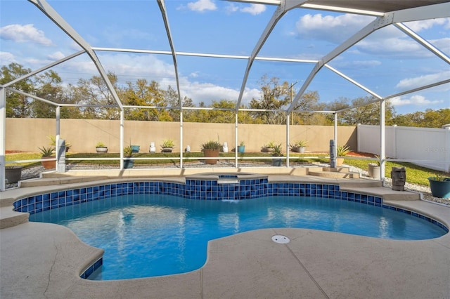 view of pool with glass enclosure, a fenced backyard, a patio, and an in ground hot tub