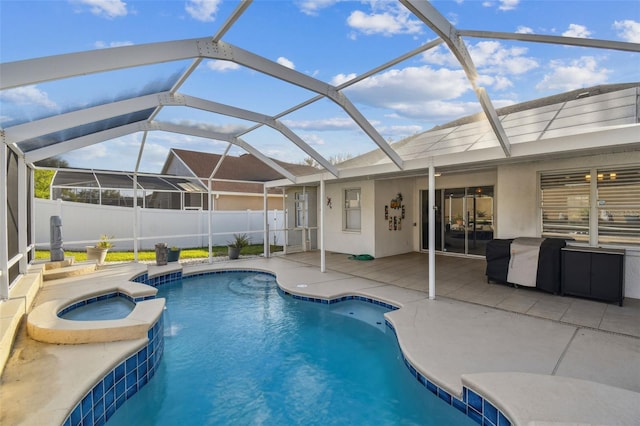 view of pool with a pool with connected hot tub, a patio area, fence, and a lanai