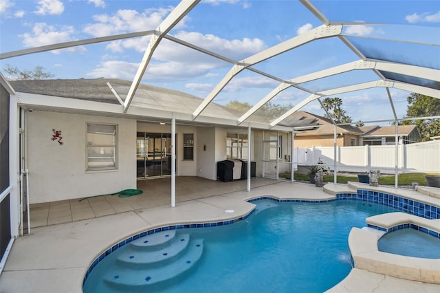 view of swimming pool with a pool with connected hot tub, a lanai, a patio area, and fence