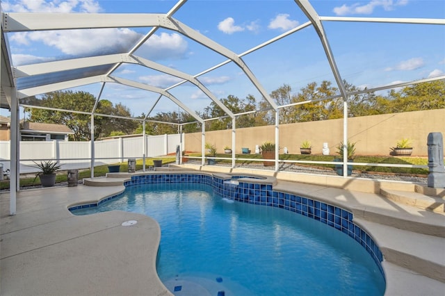 view of swimming pool featuring a fenced in pool, a patio, a fenced backyard, a jacuzzi, and a lanai