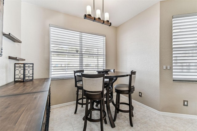 dining area featuring baseboards, plenty of natural light, and a notable chandelier