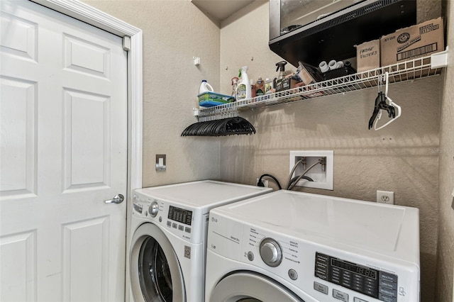 laundry area featuring laundry area, washer and clothes dryer, and a textured wall