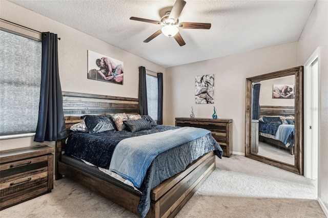 carpeted bedroom featuring a textured ceiling and ceiling fan